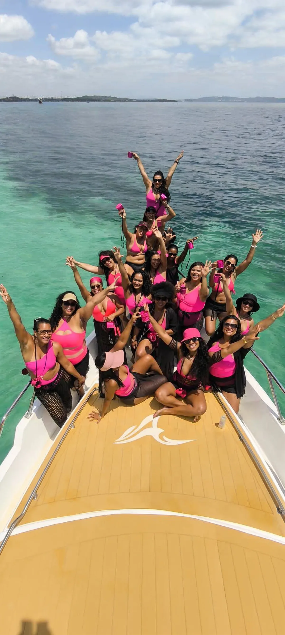 Grupo de clientes curtindo o passeio na lancha da Acalma Alma sobre o mar de Salvador