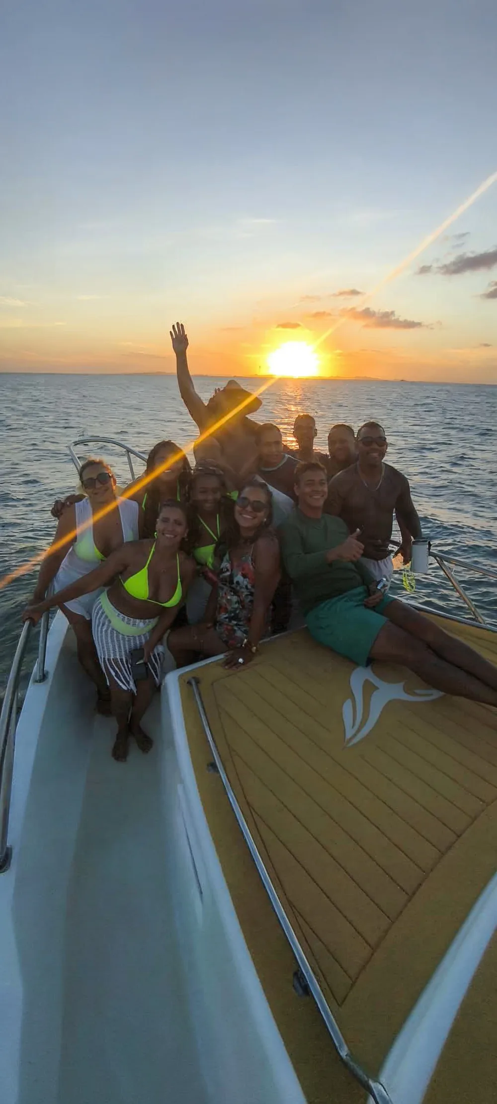 Grupo reunido na proa da lancha da Acalma Alma curtindo o pôr do sol no mar da Bahia